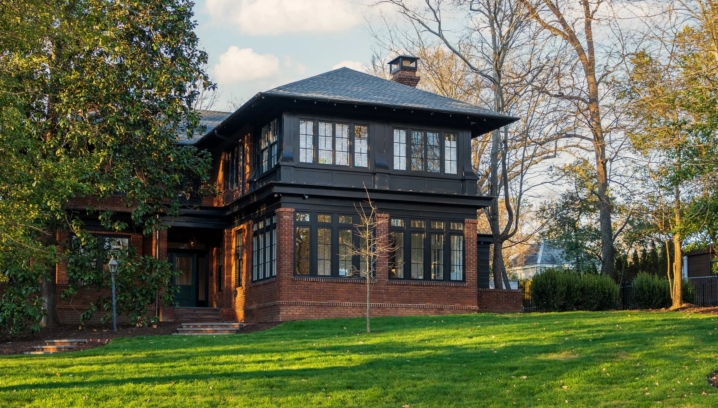 two story red brick house with landscaped front yard